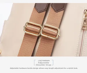 Détail de la bandoulière réglable avec boucle dorée et tirette de zip gravée