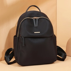 Women black Oxford cloth backpack with gold zippers and sleek lightweight travel design