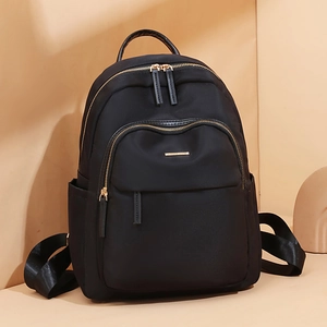 Sac à dos noir minimaliste en tissu Oxford avec fermetures éclair dorées et poches