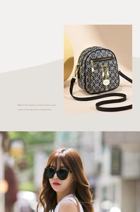 Detail of vintage patterned crossbody bag with cute cat zipper charm and layered pockets