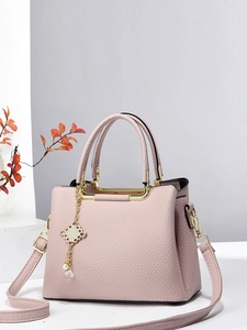 Pink minimalist faux leather tote bag with gold knot charm and adjustable strap