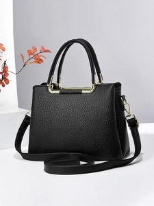Minimalist black lychee leather handbag for women with gold hardware and shoulder strap