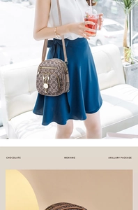 Detailed view of chocolate printed crossbody bag with golden cat pendant and zipper detail