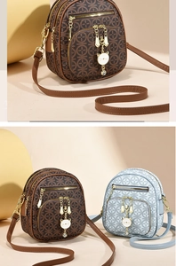 Detail of vintage pattern shoulder bag with cat pendant and golden zippers