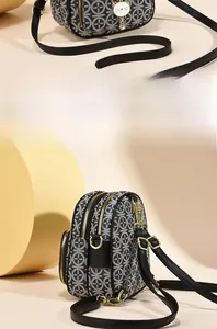 Close-up of geometric pattern shoulder bag with a white cat-shaped ornament detail