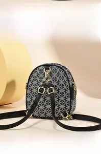 Detail view of mini shoulder bag with black and white geometric pattern and gold hardware