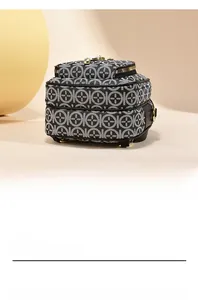 Detail of compact floral pattern shoulder bag with triple gold zippers and sturdy base studs