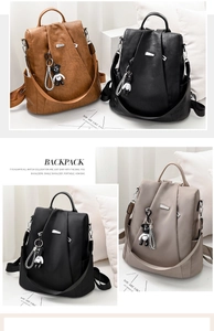 Detail view of four oxford and leather backpacks with bear charms and metal handles