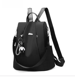 Oblique view of a black oxford backpack featuring a cute bear keychain and metal zippers