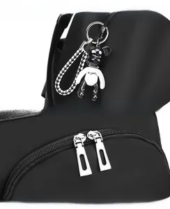 Detail of black oxford backpack featuring a resin bear charm and premium silver metal zippers