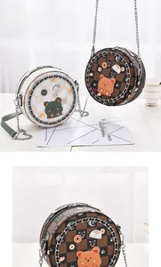 Detail runder Mini-Umhängetaschen mit Schachbrettmuster und süßen Cartoon-Aufnähern