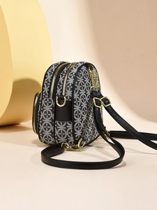 Fashionable crossbody bag with black and white geometric print and golden zipper detail