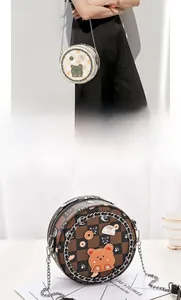 Details von runden Umhängetaschen mit Karomuster und süßen Cartoon-Drucken