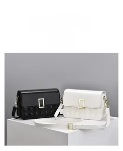 Detail of quilted leather crossbody bags in black and white with gold metal buckles