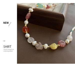 Detail of beaded necklace with freshwater pearls, colorful natural stones and gold spacers