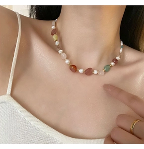 Detail of colorful gemstone and freshwater pearl collar necklace on model neck