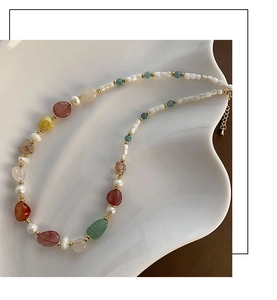 Detailed close-up of colorful natural gemstone choker with pearls on a white wave tray
