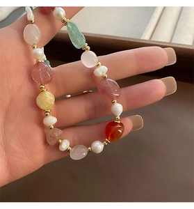 Close-up of natural stone and freshwater pearl necklace with gold-toned metal spacers
