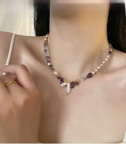 Close-up of amethyst and baroque pearl necklace set worn on neck with golden beads
