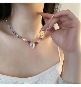 Close-up of Baroque pearl and amethyst beaded necklace worn on a model's neck