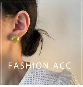 Close-up of vintage-style green cat-eye resin stud earrings on a model with lace top