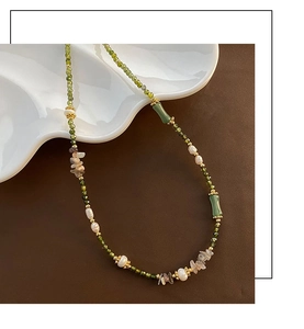 Detail of vintage necklace with green beads, freshwater pearls and bamboo jade accents