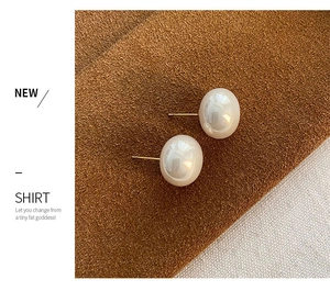 Macro detail of large round pearls with elegant gold metal studs on dark leather