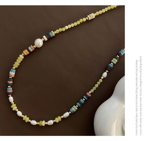 Macro view of multi-material beaded necklace with baroque pearls and colorful gemstone beads