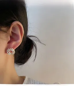 Macro shot of French wheat-inspired gold stud earrings with marquise stones and zircons