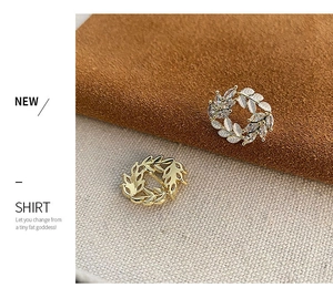 Macro detail of wheat ear stud earrings with marquise rhinestones and silver metal finish