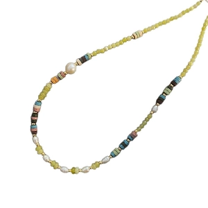Retro beaded necklace with olivine, pearl and colorful volcanic stones on white background