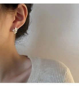 Gros plan de boucles d'oreilles fleurs blanches élégantes avec perles sur un mannequin