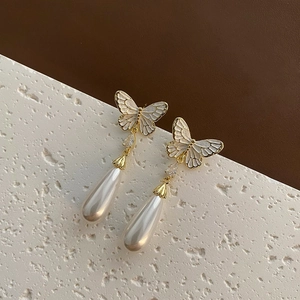 Elegant French butterfly drop earrings with white pearls and gold trim on stone base
