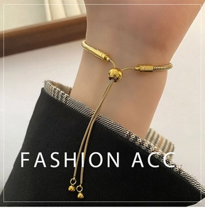 Detailed view of adjustable golden snake chain bracelet with sliding bead closure on wrist