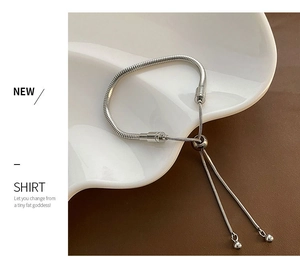 Detail of adjustable silver snake chain bracelet with sliding clasp and spherical charms