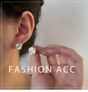 Close-up of white camellia flower stud earrings with pearlescent shell texture details