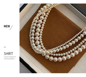Gros plan d'un collier de perles à quatre couches sur un plateau en velours
