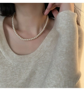 Gros plan d'un collier de perles élégant porté au cou avec un éclairage doux