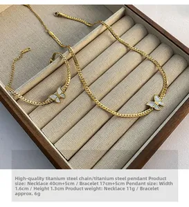 Detail of gold titanium steel butterfly necklace and bracelet set with white shell inlay