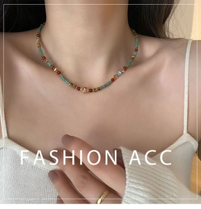 Gros plan de perles en pierre naturelle multicolores sur un collier bohème délicat