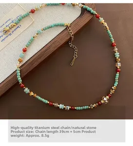 Gros plan d'un collier ethnique avec pierres naturelles rouges et vertes et chaîne acier