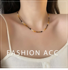 Macro detail of faceted tiger eye beads and colorful stone choker necklace on neck