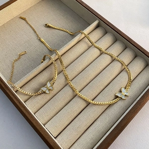 Elegant gold butterfly jewelry set featuring shell inlay necklace and bracelet in a box