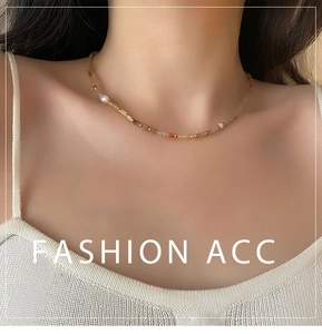 Détail d'un collier de perles colorées avec perle d'eau douce sur un mannequin en tricot