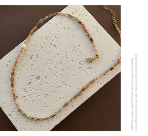Détail d'un collier de perles colorées fait main avec perle d'eau douce sur une pierre