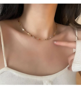 Détail du collier de perles d'eau douce colorées porté au cou par un mannequin