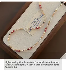 Detailed view of beaded necklace with pink and red natural stones on a wood jewelry box