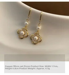 Makroaufnahme goldener Blumenohrringe mit Zirkonia-Besatz und Perlendetails