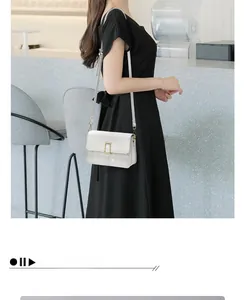 Detail view of white quilted leather crossbody bag worn on shoulder by model