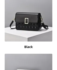 Detailed close-up of a black quilted leather shoulder bag with a gold rectangular buckle
